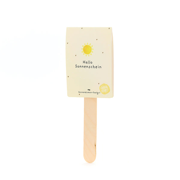Holzstab mit einer gelben Karte, auf der "Hallo Sonnenschein" und eine Sonne abgebildet sind.