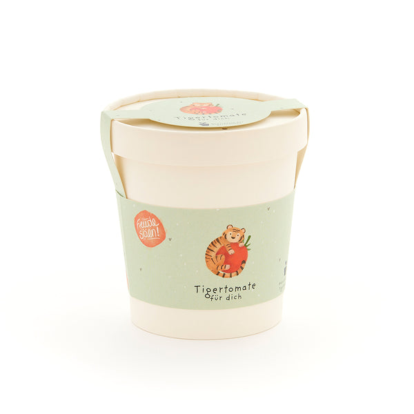 Becher mit grünem Etikett, auf dem ein Tiger mit einer Tomate und der Text "Tigertomate für dich" abgebildet ist.