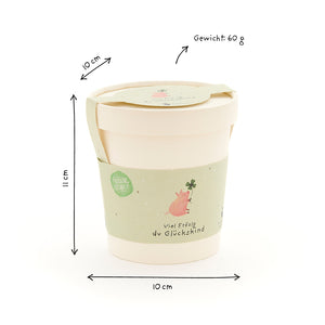 Becher mit grünem Etikett, Schweinchen und Kleeblatt, Maße 11 cm hoch, 10 cm Durchmesser, Gewicht 60 g.