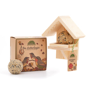 Bio-Leckerbissen für Vögel mit Vogelfutterhaus und Verpackung auf weißem Hintergrund.