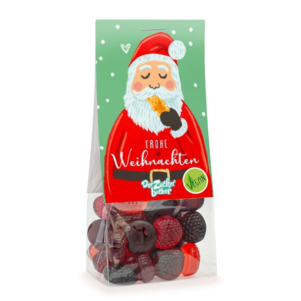 Verpackung mit veganen Weihnachtssüßigkeiten und einem Bild des Weihnachtsmanns, der ein Plätzchen isst, mit der Aufschrift 'Frohe Weihnachten'.