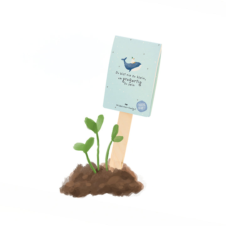 Ein kleiner Pflanzensprössling wächst aus Erde, daneben steckt ein Schild mit der Aufschrift „Du bist nie zu klein, um großartig zu sein“ und einer Illustration eines Wals.