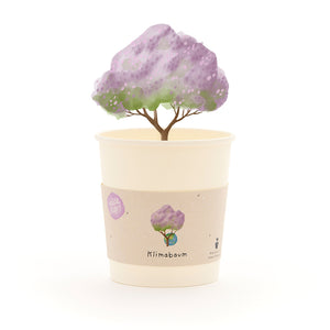 Becher mit einem gezeichneten Baum mit lila Blättern und dem Schriftzug "Klimabaum" auf dem Etikett.