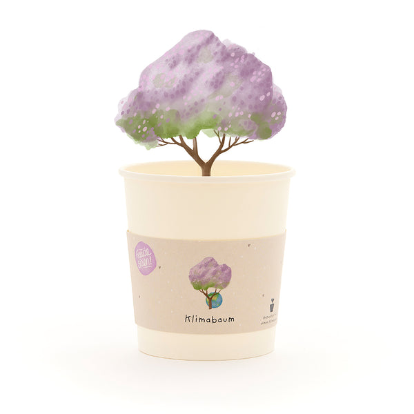 Becher mit einem gezeichneten Baum mit lila Blättern und dem Schriftzug "Klimabaum" auf dem Etikett.