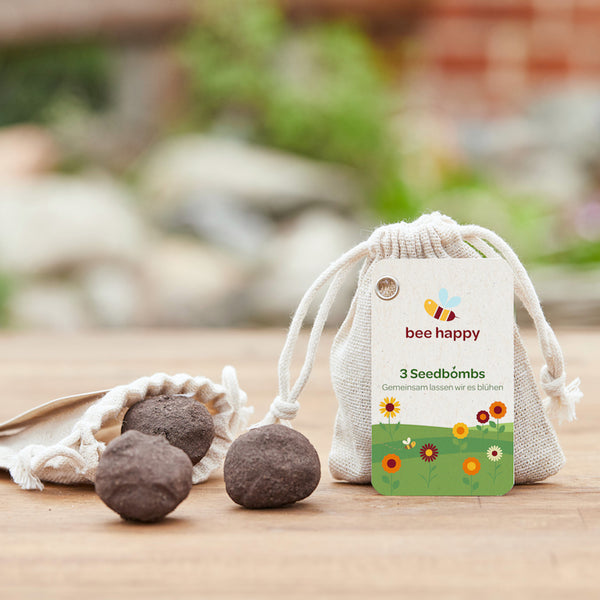 3 zaadbommetjes in een katoenen zakje met een individueel hanglabel.
