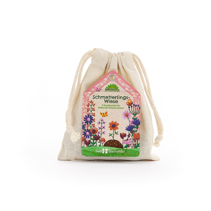 Beiger Stoffbeutel mit bunter Etikette, die "Schmetterlings-Wiese" und eine Blumenwiese zeigt.