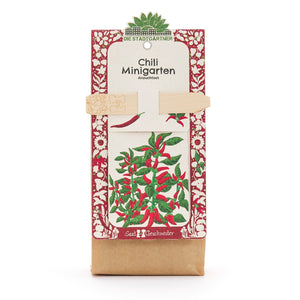 Chili Minigarten Anzuchtset von Die Stadtgärtner mit rotem und grünem Pflanzenmotiv auf der Verpackung.