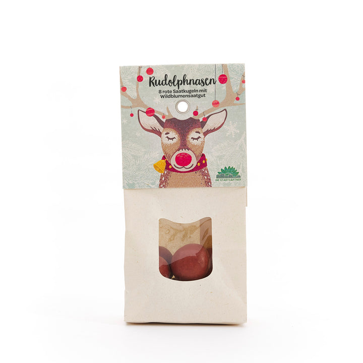 Papiertüte mit Aufdruck eines Rentiers und dem Text "Rudolphnasen – 8 rote Saatkugeln mit Wildblumensaatgut", darunter ein Sichtfenster mit roten Saatkugeln.