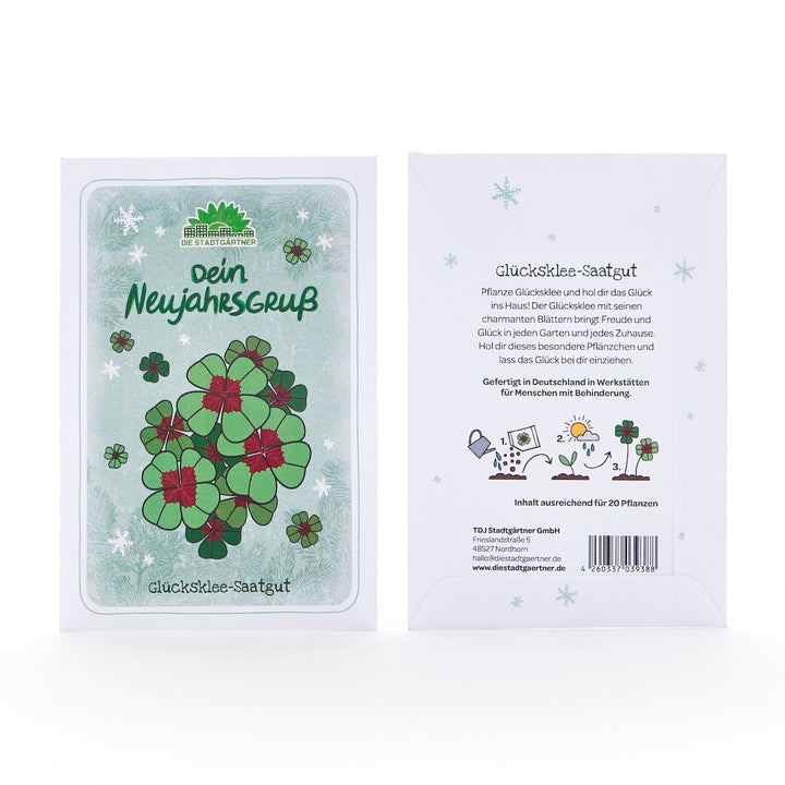 Zwei Tütchen Glücksklee-Saatgut, vorne mit Illustration von vierblättrigem Klee und Text "dein Neujahrsgruß", hinten mit Anleitung und Beschreibung auf Deutsch.