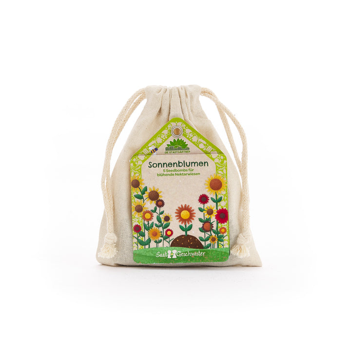 Stoffsäckchen mit Etikett "Sonnenblumen Seedbombs" und bunten Blumenillustrationen.
