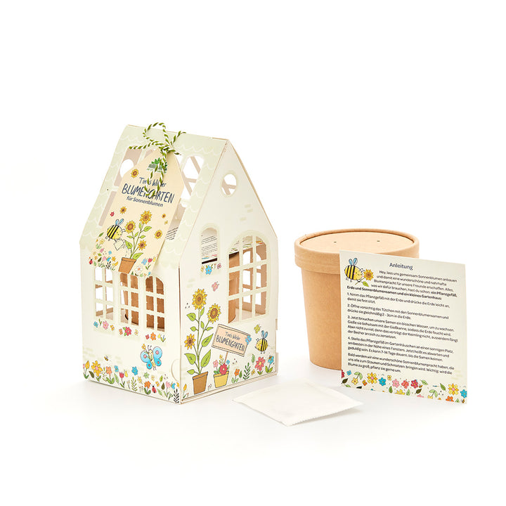 Blumengarten-Bastelset mit dekorativem Häuschen, Blumentopf, Samenpäckchen und Anleitung auf Deutsch.