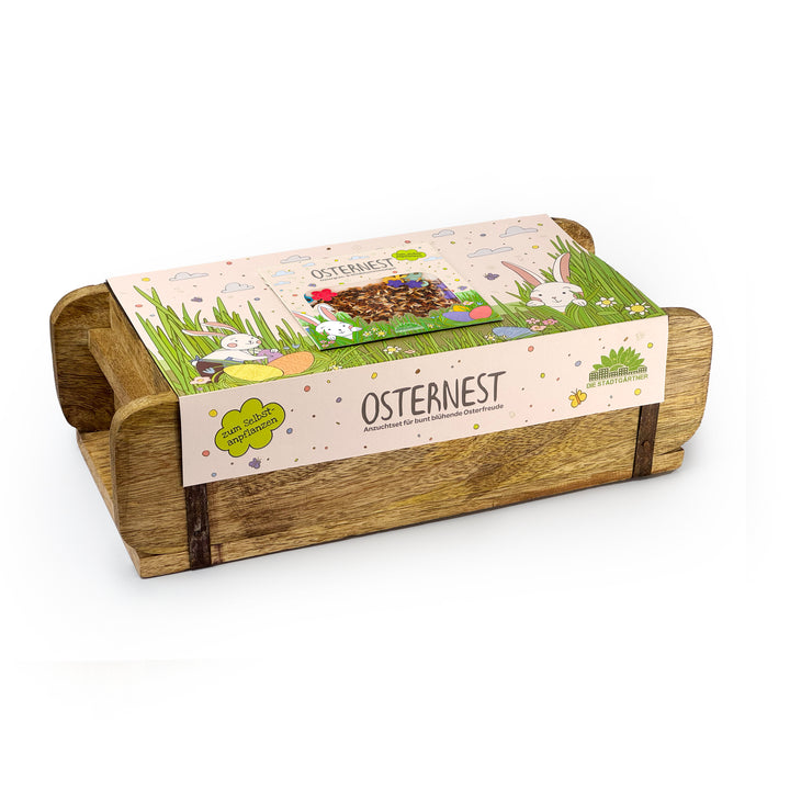 Holzschale mit Osterdekoration und Verpackung, beschriftet mit "Osternest" und Hasenmotiven.