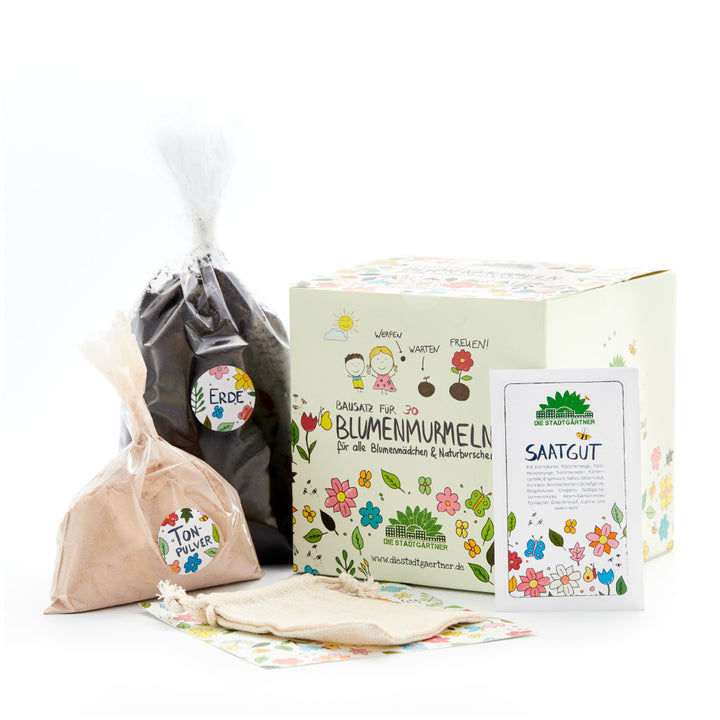 Blumensamen-Set mit Box, Tüte Erde, Tüte Tonpulver, Samentüte und Stoffbeutel, alles bunt illustriert.
