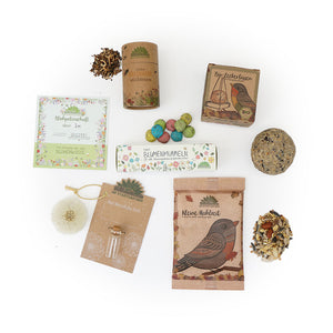 Verschiedene Gartenzubehör- und Samenverpackungen auf weißem Hintergrund.