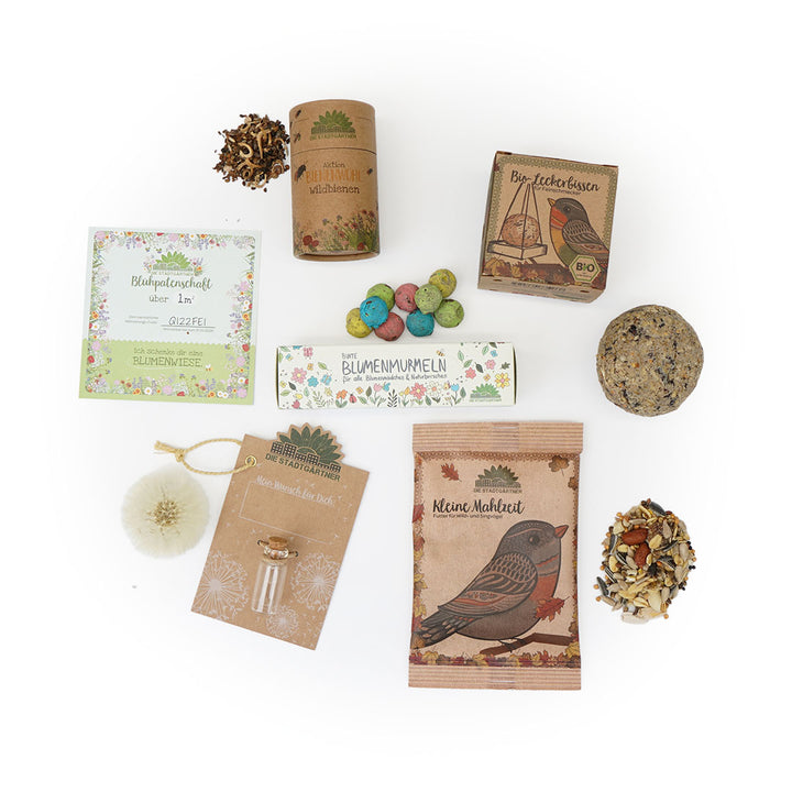 Verschiedene Gartenzubehör- und Samenverpackungen auf weißem Hintergrund.